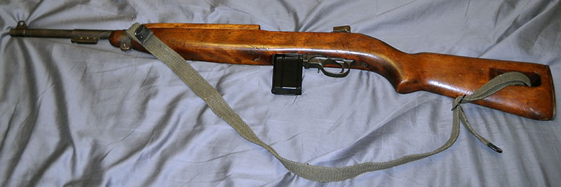 M1 carbine, left side, with sling and 15-round magazine attached
